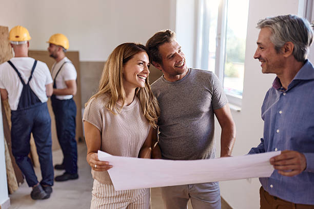 istock Happy couple working on plans with an architect during home renovation process. 2224422858