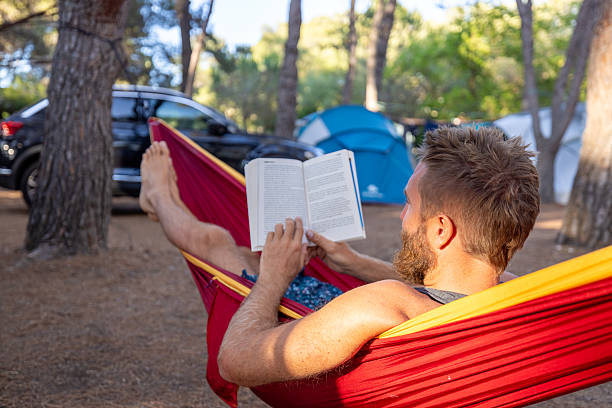 istock Man Relaxing and Reading Book in Hammock 2224423435
