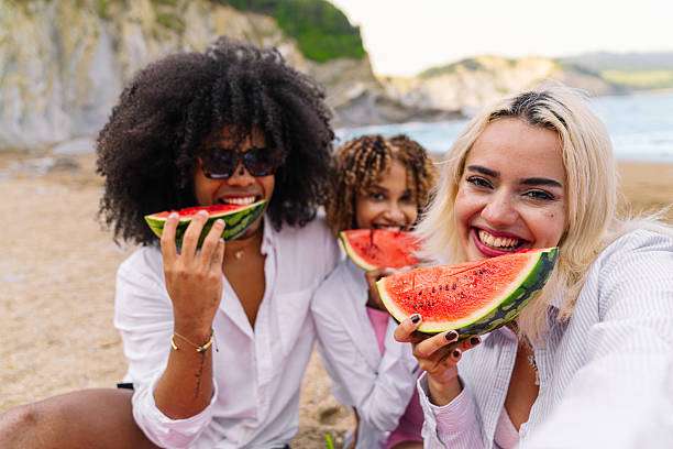 istock Multiracial friends enjoying watermelon on the beach 2224424068