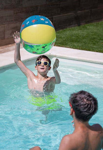 istock Children playing with inflatable ball in swimming pool 2224424201