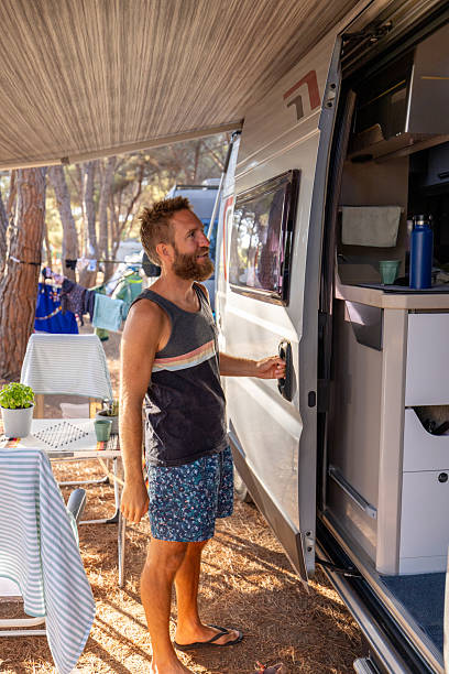 istock Man Opening Camper Van Door at Campsite 2224424521