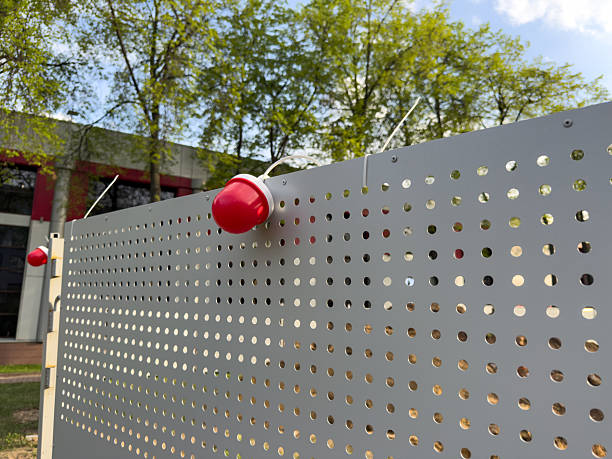 istock Modern perforated metal fence with red dome lights 2224428081