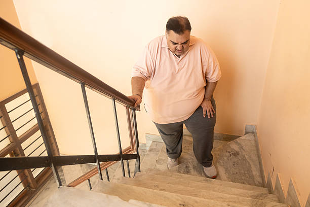 istock Overweight indian man have difficulty climbing stairs, Plus size guy have knee pain and fatigue. fitness healthcare, obesity. Lose weight, 2224428650