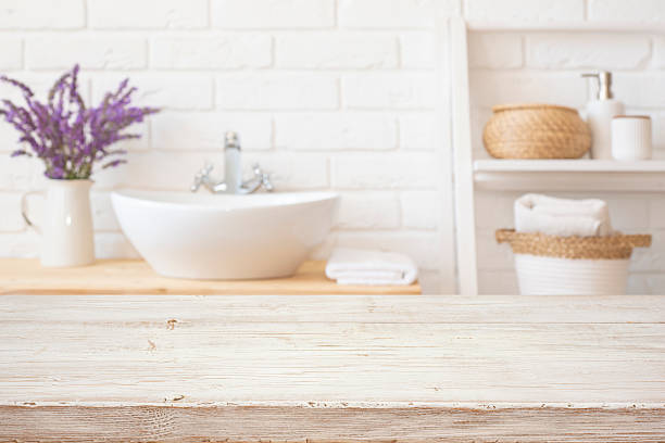 istock Light blurred bathroom background with mock up space for product display on bleached wooden table top in front 2224430795