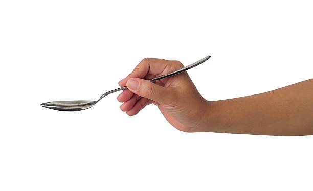 istock female hand holding a spoon 2224433486