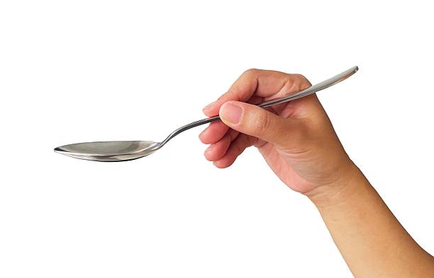 istock hand holding metal spoon on white 2224433488