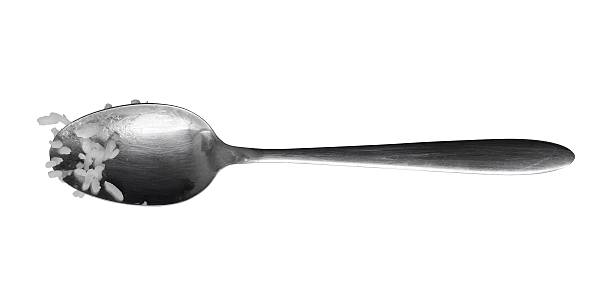 Single wooden handle spoon on a table with a clean white background, ample Copy Space, representing simplicity and minimalism in everyday life, suitable for cooking, home, and lifestyle imagery.