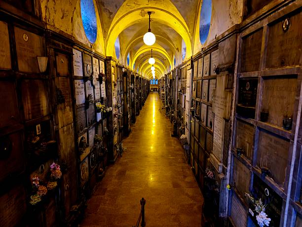 Monumental Cemetery of Milan with a large grave gallery illuminated by electric lamps. The cemetery was realized after plas by  the architect Carlo Maciachini (1818–1899).