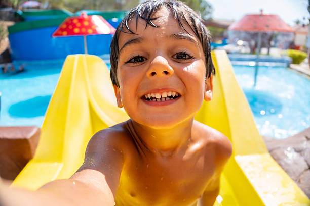 istock Happy child taking a selfie on a waterslide at a water park 2224435505