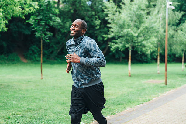 istock Smiling man jogging outdoors in the park. 2224436754