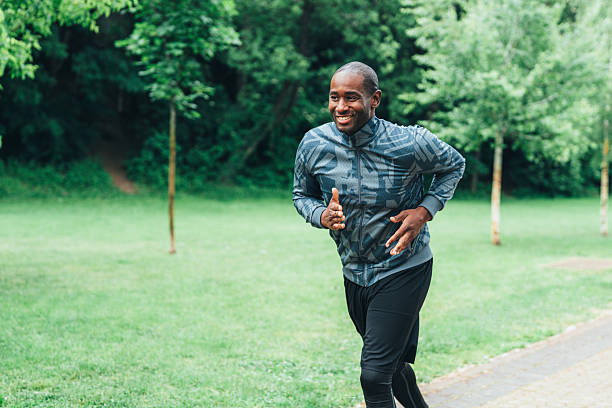 istock Smiling man jogging outdoors in the park. 2224436757