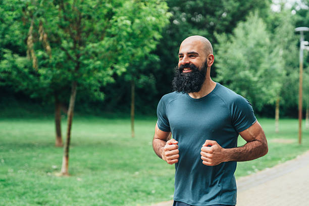 istock Smiling man jogging outdoors in the park. 2224436774