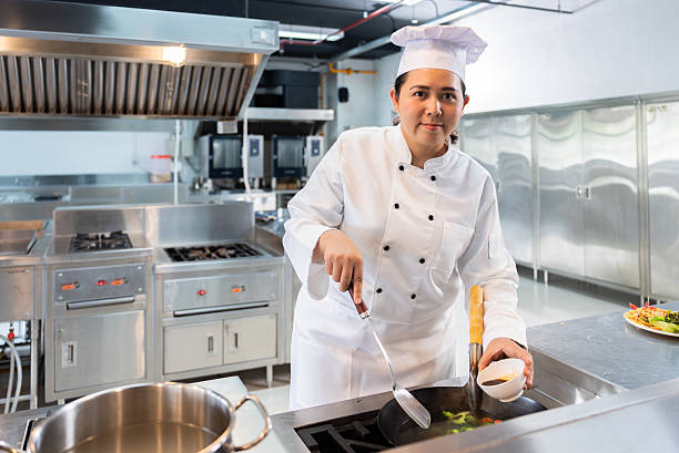istock Confident Mid-Age Asian Female Chef Preparing Dish in Modern Restaurant Kitchen 2224438103