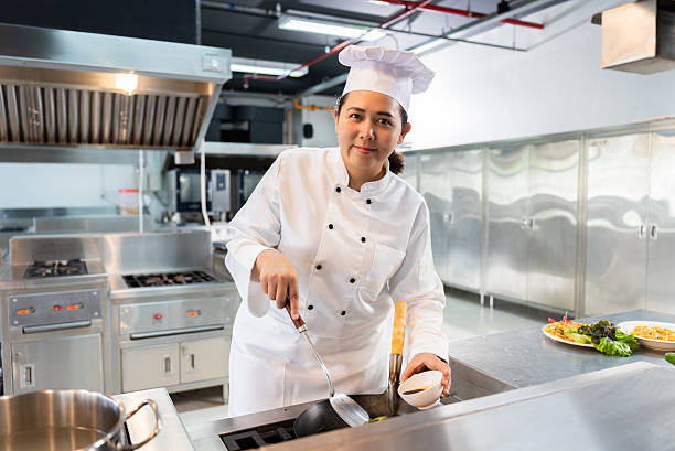 istock Confident Mid-Age Asian Female Chef Preparing Dish in Modern Restaurant Kitchen 2224438105
