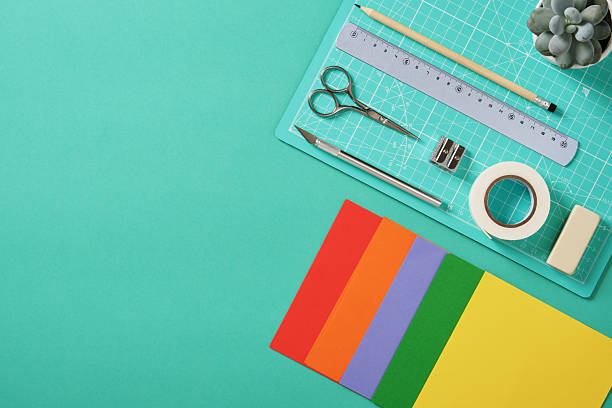 istock Workspace for paper crafts. Turquoise cutting mat, colored paper, pencils, tape, ruler, scissors. Space for your text. 2224438511