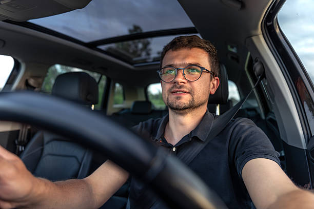 istock Man driving car. Positive emotions. Bright daylight interior. 2224439772