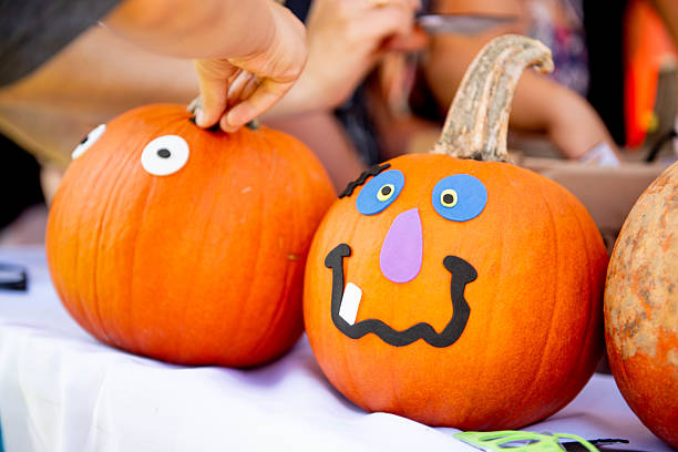 Creative pumpkins decorated by kids, featuring orange pumpkins with googly eyes and painted silly faces, showing alternative Halloween decoration techniques. Perfect for family-friendly craft projects and non-scary Halloween activities.