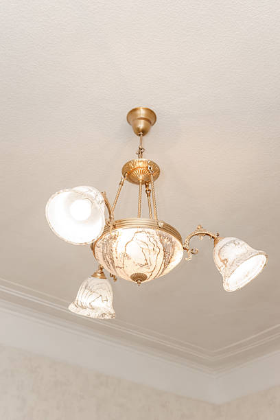 istock Image of a vintage chandelier with ornate marble shades, captured in a broken state. The delicate design features elaborate metalwork and intricate artistry, highlighting its antique charm. 2224449607