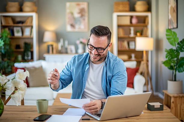 istock Happy freelancer working from home reviewing documents and smiling 2224451977