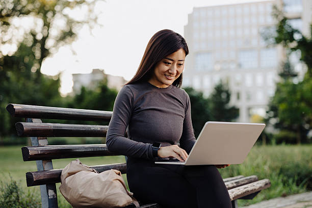 istock Chinese female student using laptop outdoor 2224452905