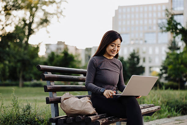 istock Chinese female student using laptop outdoor 2224452997