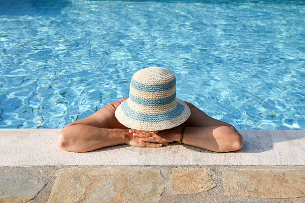 istock Senior Woman Resting By The Pool With Sun Hat 2224453303