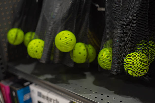istock Functional, space-efficient sports equipment management, retail environments tidy storage solutions pickleball paddles and yellow balls stored in mesh bags hanging from perforated metal shelving 2224454144