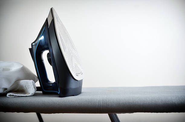 istock Clothes ironing concept with iron on ironing board isolated background 2224459027