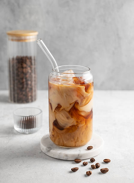 istock Ice latte coffee in a glass with milk on a marble board on a  light background with coffee beans. 2224463316