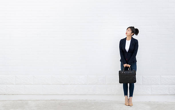 istock Confident woman standing and holding a briefcase 2224463772