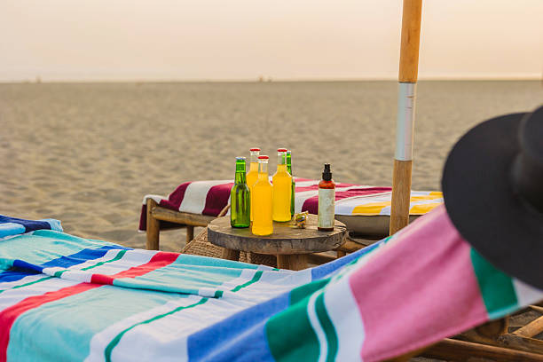 istock Relaxing on beach chairs with drinks and sunscreen at sunset 2224464569