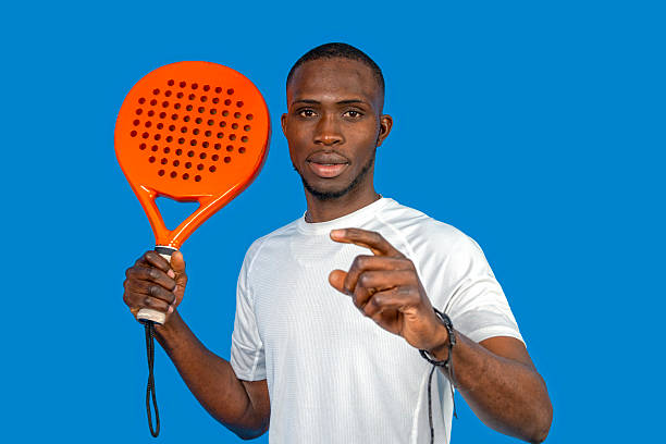 istock Padel player holding racket and pointing finger on blue background 2224464583