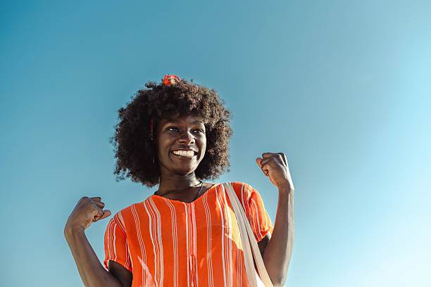 istock Joyful woman celebrating outdoors under a clear blue sunny sky 2224466736