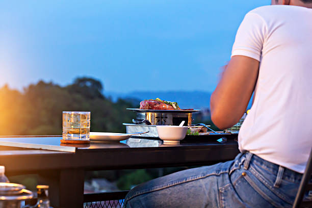 Dining experience with grilled food and drinks on restaurant terrace during sunset with scenic view