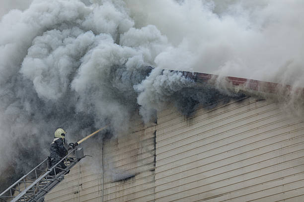 istock Firefighter Extinguishing Burning Building with Heavy Smoke During Emergency Rescue Operation 2224470126