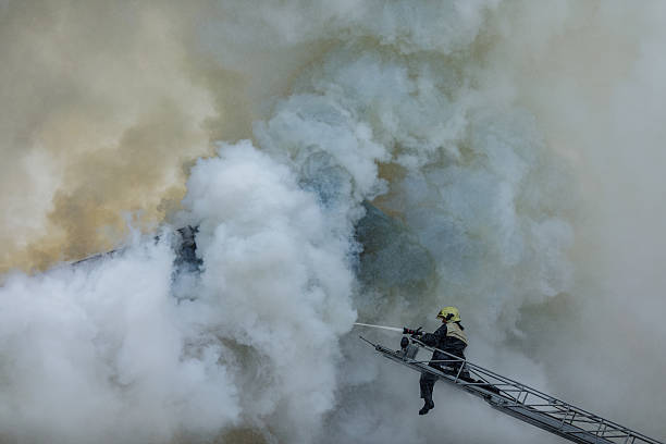 istock Firefighter Battling Smoke and Flames on Ladder During Emergency Rescue Operation 2224470132