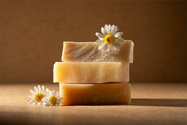 Stack of handmade organic soap bars decorated with fresh chamomile flowers
