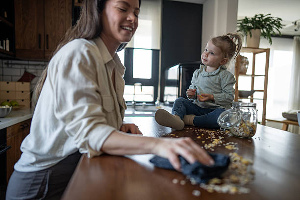 istock Mother cleaning kitchen table after daughter's messy meal 2224471467