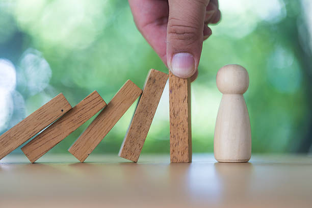 istock Hand  who is stopping or preventing a falling block to people. Risk protection concept. Eliminating the risk 2224473492