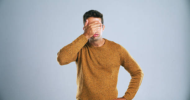 istock Frustrated, upset and man with hand on face in studio for mistake, disappointment or fail. Stress, anxiety and male person with shame for bad decision, choice or fake news by gray background. 2224474881