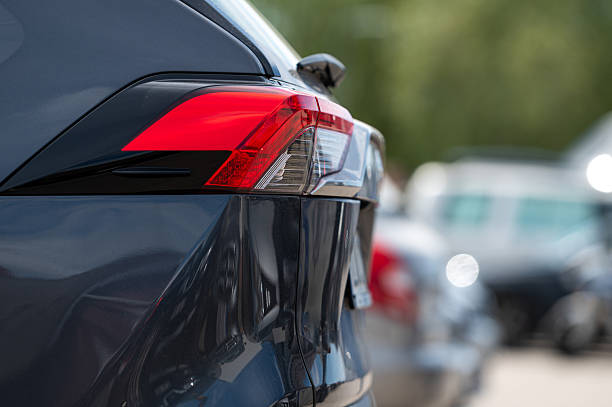 istock Red tail light glows on a parked vehicle in a busy lot during daylight hours 2224477129