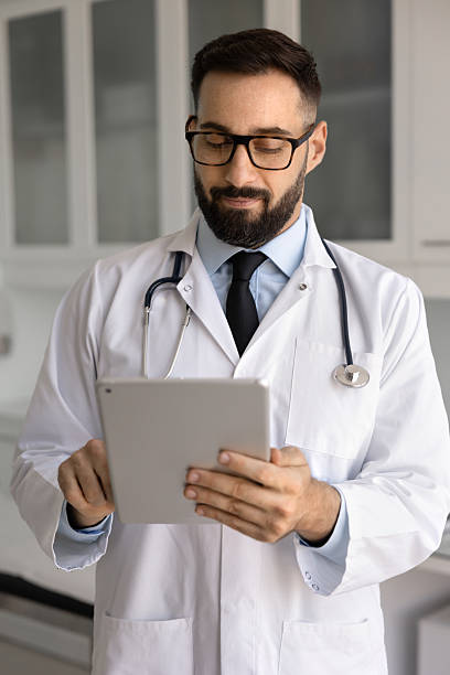 istock Positive doctor man thumbing through chats with patients 2224477734