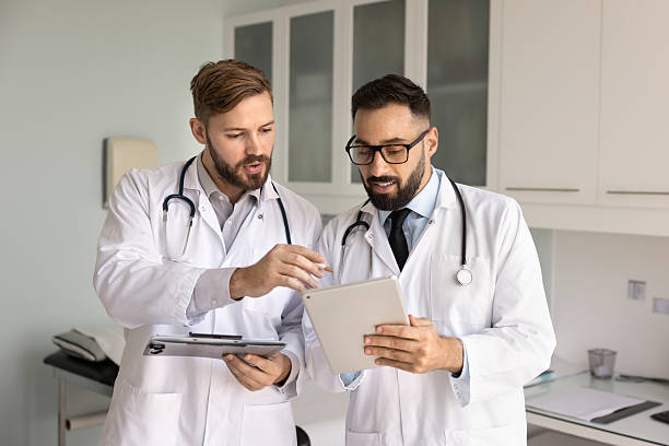 istock Focused male Hispanic physician man asking coworker for help 2224478762