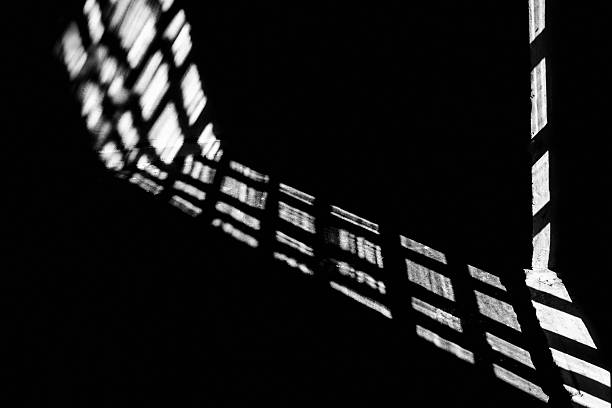 istock Abstract background, the shadow of a window frame cast on a dark surface. The strong contrast. 2224481101