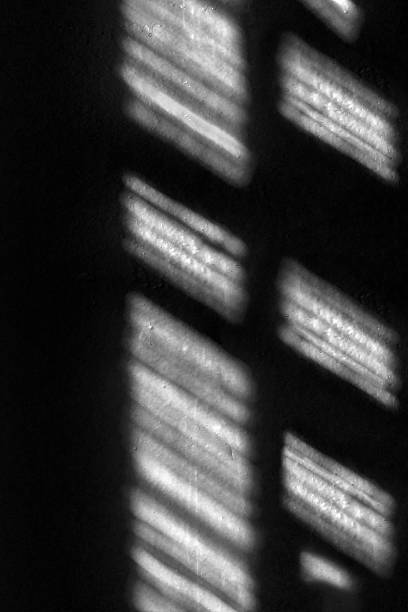 istock Abstract background, the shadow of a window frame cast on a dark surface. The strong contrast. 2224481121