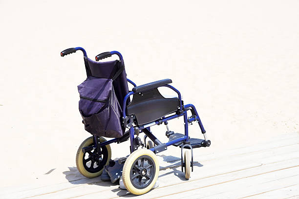 disability-friendly vacations. wheelchair on a wooden platform on a beach.