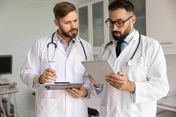 istock Two serious doctors in lab coats discussing medical case 2224483543