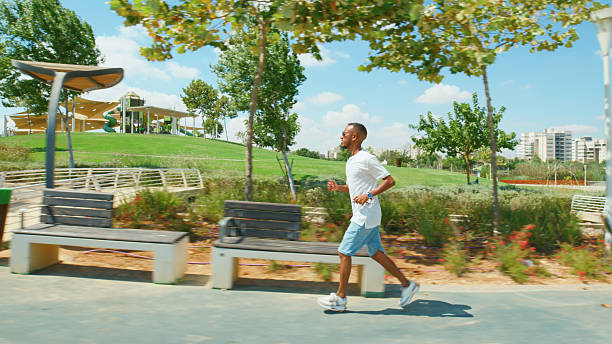 istock Young Adult Jogging in Urban Park Setting 2224485438