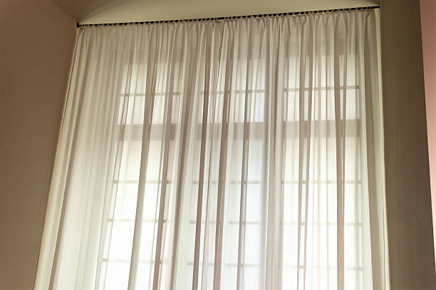 istock Softly lit room with sheer white curtains on large windows 2224485439