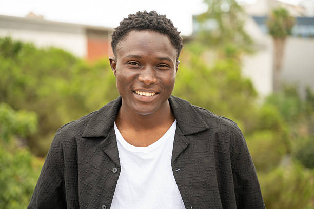 istock Young man smiling outdoors in an urban setting 2224486833
